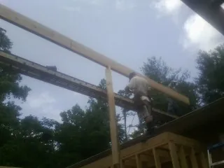Carpenter setting a ridge beam over a new addition frame — Ice Dam Removal by Roofing Brothers in Nyssa